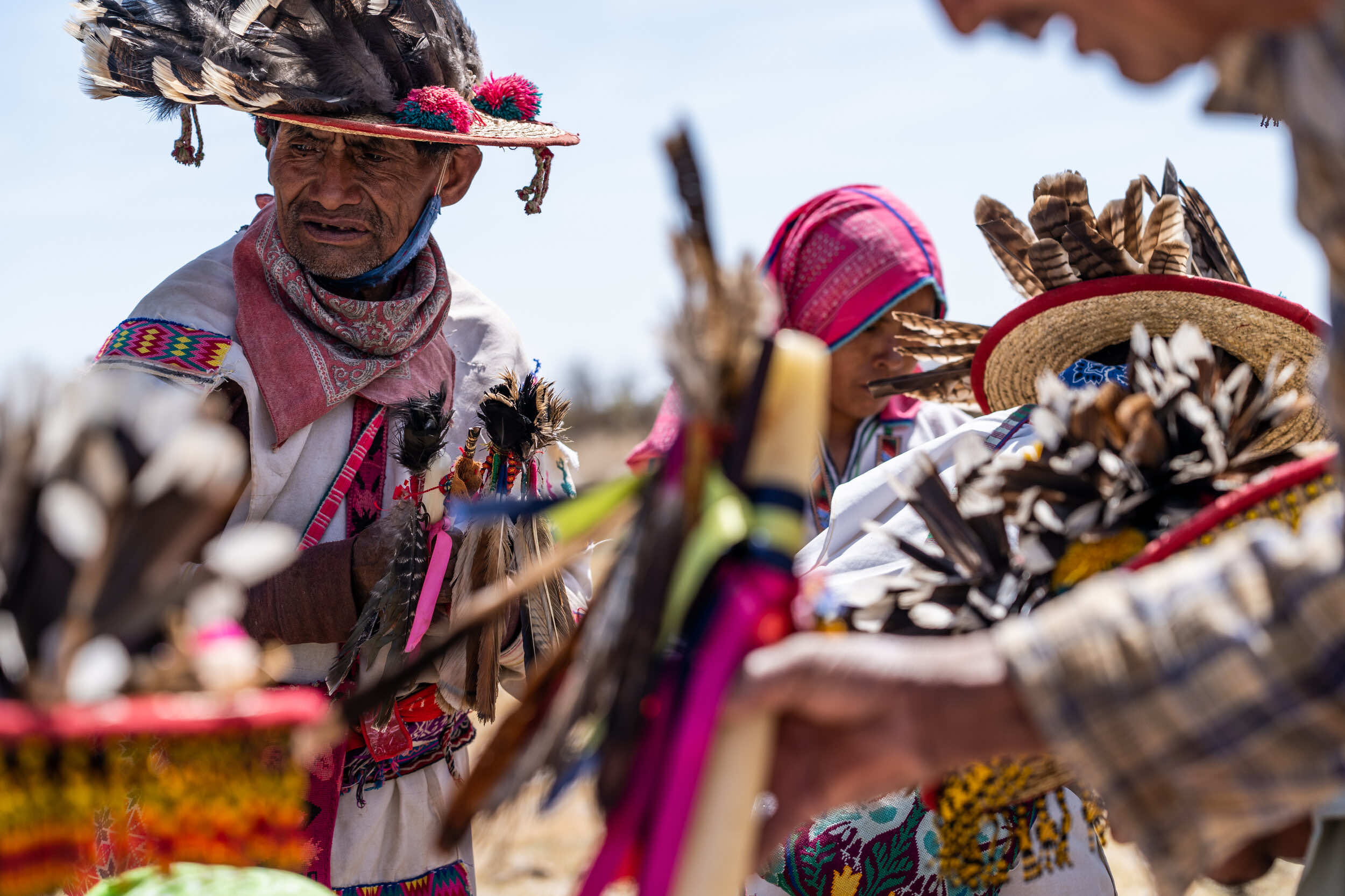 Miembros de la comunidad wixárika participando en una ceremonia tradicional, mostrando el profundo vínculo espiritual y cultural que mantienen con sus tierras sagradas.