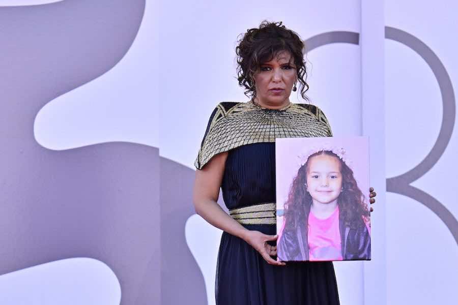 La cineasta tunecina Kaouther Ben Hania, en la alfombra roja de la Mostra de Venecia, sostiene el retrato de Hind Rajab, la niña palestina asesinada en Gaza e inspiradora de su película The Voice of Hind Rajab.